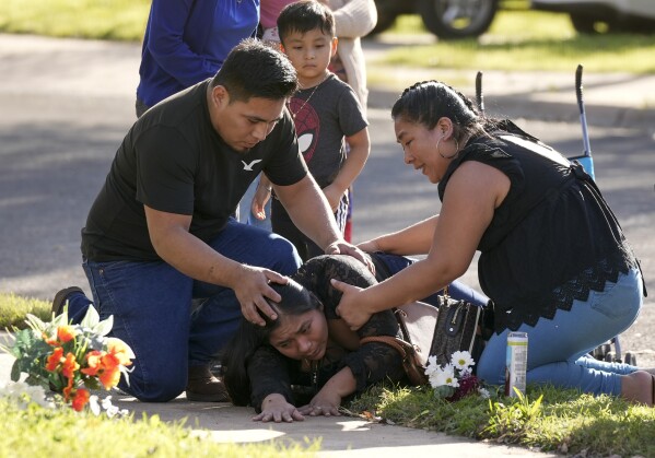 Domatilia Caal, center, is consoled by her brother, Cornelio, and sister Filomena, on Wednesday, Dec. 6, 2023, in Austin, Texas, at the site where her husband was killed in a violent trail of separate attacks on Tuesday. (Jay Janner/Austin American-Statesman via AP)