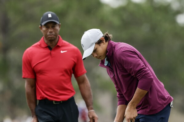 FILE -Tiger Woods, left, watches his son Charlie, right, putt ball during the final round of the PNC Championship golf tournament Sunday, Dec. 17, 2023, in Orlando, Fla. Charlie Woods, 15, will be playing a pre-qualifier on Thursday in Hobe Sound, Fla., the first step before a full qualifier for the Cognizant Classic on the PGA Tour. (AP Photo/Kevin Kolczynski, File)