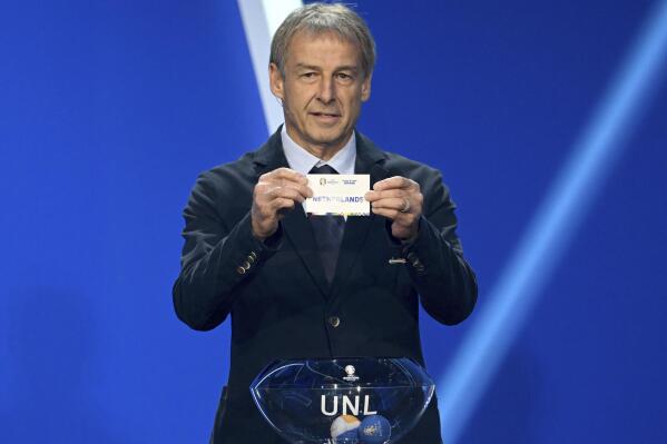Juergen Klinsmann, former soccer player and soccer official, holds the lot of The Netherlands during the draw for the groups to qualify for the 2024 European soccer championship in Frankfurt, Germany, Sunday, Oct.9, 2022.  (Arne Dedert/dpa via AP)