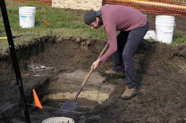 Archeological technician Makenzie Coufal clears soil away soil as workers dig for the suspected remains of children who once attended the Genoa Indian Industrial School, Tuesday, July 11, 2023, in Genoa, Neb. The mystery of where the bodies of more than 80 children are buried could be solved this week as archeologists dig in a Nebraska field that a century ago was part of a sprawling Native American boarding school. (AP Photo/Charlie Neibergall)