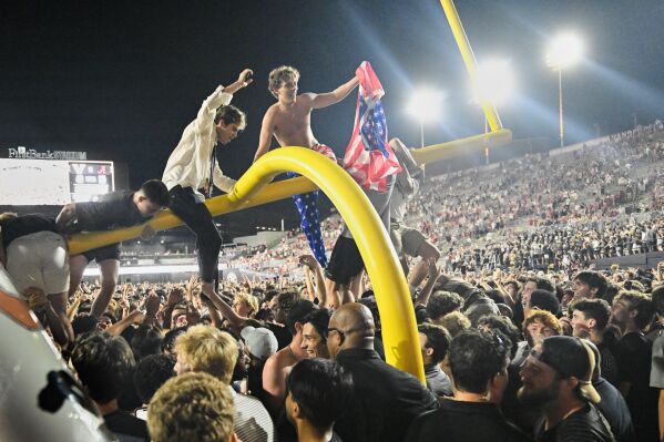 Vanderbilt fans climb a goalpost as they celebrate on the field after defeating Alabama in an NCAA football game, Saturday, Oct. 5, 2024, in Nashville, Tenn. (AP Photo/John Amis, File)