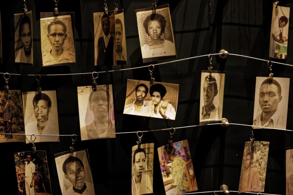 FILE - Family photographs of some of those who died hang on display in an exhibition at the Kigali Genocide Memorial centre in the capital Kigali, Rwanda Friday, April 5, 2019. A 68-year-old Rwandan doctor who has been living in France for decades goes on trial Tuesday in Paris over his alleged role in the 1994 genocide in his home country. The doctor, Sosthene Munyemana, is facing charges of genocide, crimes against humanity and complicity of such crimes. (AP Photo/Ben Curtis, File)