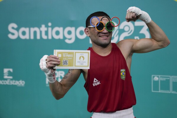 El brasileño Mikel da Silva celebra después de derrotar al argentino Ramón Quiroga en la división de boxeo masculino de 51 kg en los Juegos Panamericanos en Santiago, Chile, el jueves 26 de octubre de 2023.  (Foto AP/Martín Mejía)