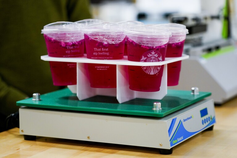 Plastic cups for cold drinks undergo a shake test on an orbital shaker at the Tryer Center at Starbucks headquarters, Wednesday, June 28, 2023, in Seattle. Technicians look for leaks and flaws. (AP Photo/Lindsey Wasson)