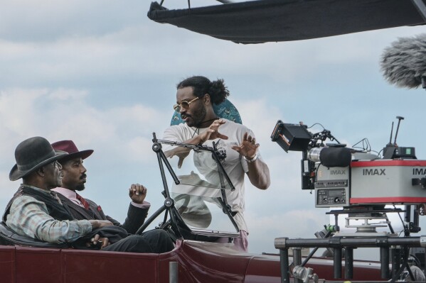 This image released by Warner Bros. Pictures shows actors Delroy Lindo, from left, and Michael B. Jordan with director-writer-producer Ryan Coogler on the set of "Sinners." (Eli Adé/Warner Bros. Pictures via AP)