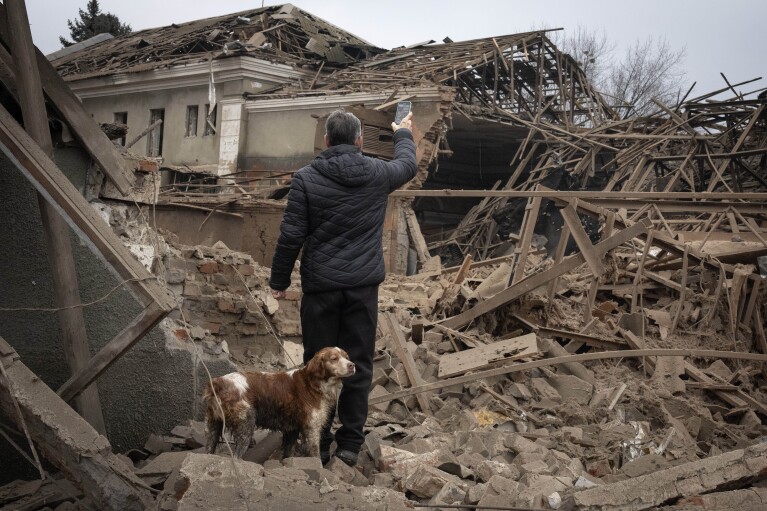 FILE - A local resident looks at the of an industrial building surrounded by apartment houses after a night Russian rocket attack in Sloviansk, Ukraine, Saturday, Jan. 27, 2024. Approval by the U.S. House of a $61 billion package for Ukraine puts the country a step closer to getting an infusion of new firepower. But the clock is ticking. Russia is using all its might to achieve its most significant gains since the invasion by a May 9 deadline. (AP Photo/Efrem Lukatsky, File)