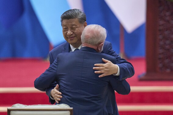 Chinese President Xi Jinping hugs Brazilian President Luiz Inacio Lula da Silva after delivering his opening speech for the opening ceremony of the Fourth Ministerial Meeting of the Forum of China and Community of Latin American and Caribbean States at China National Convention Center in Beijing, Tuesday, May 13, 2025. (AP Photo/Andy Wong)