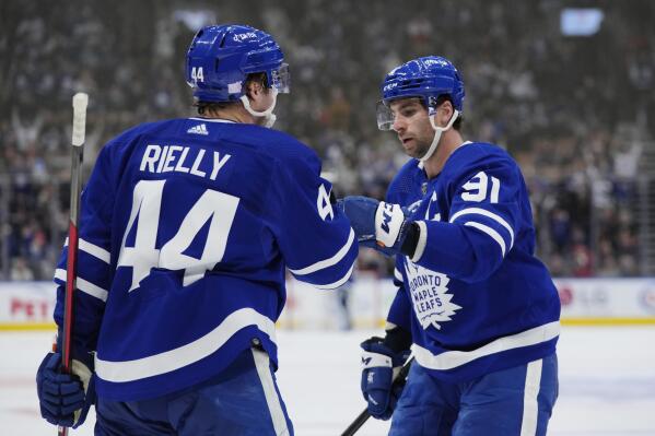 Toronto Maple Leafs defenseman Morgan Rielly (44) celebrates his goal against the New York Rangers with teammate John Tavares (91) during second-period NHL hockey action in Toronto, Thursday, Nov. 18, 2021. (Nathan Denette/The Canadian Press via AP)