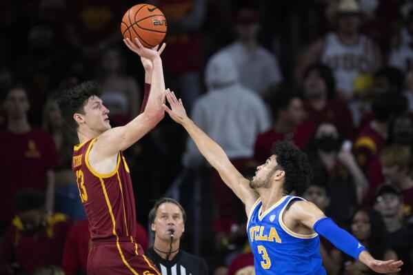 Southern California guard Drew Peterson (13) shoots over UCLA guard Johnny Juzang (3) during the first half of an NCAA college basketball game Saturday, Feb. 12, 2022, in Los Angeles. (AP Photo/Kyusung Gong)