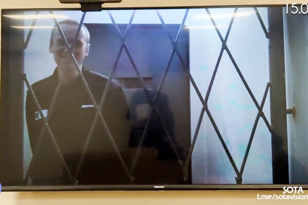 This photo taken from video released by Russian Federal Penitentiary Service via SOTAVISION shows Russian opposition leader Alexei Navalny appears via a video link from the Arctic penal colony in Kharp, in the Yamalo-Nenetsk region about 1,900 kilometers (1,200 miles) northeast of Moscow, where he is serving a 19-year sentence, in Kovrov, Russia, on Feb. 15, 2024. Shortly after Navalny's death was reported on Friday Feb. 16, 2024, the Russian SOTA social media channel shared images of the opposition politician reportedly in court yesterday. In the footage, Navalny is seen standing up and is laughing and joking with the judge via video link. (Russian Federal Penitentiary Service via SOTAVISION via AP)