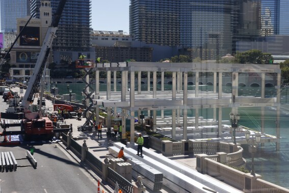 Workers stand at a Formula One construction site at the Bellagio fountains on Monday, Sept. 25, 2023, in Las Vegas. A worker who died during the weekend of an injury received at a temporary Formula One Las Vegas Grand Prix grandstand construction site at the Bellagio resort fountains was identified Monday by authorities. (Bizuayehu Tesfaye/Las Vegas Review-Journal via AP)