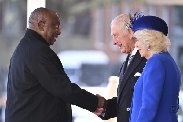 President of South Africa Cyril Ramaphosa shakes hands with Britain's King Charles III and Camilla, the Queen Consort during for a welcome ceremony at Horse Guards, in London, Tuesday, Nov. 22, 2022. This is the first state visit hosted by the UK with King Charles III as monarch, and the first state visit here by a South African leader since 2010. (Leon Neal/Pool Photo via AP)