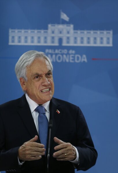 Chilean President Sebastián Piñera addresses the nation from La Moneda presidential palace, amid ongoing demonstrations triggered by an increase in subway fares in Santiago, Chile, Monday, Oct. 21, 2019. Protesters defied an emergency decree and confronted police in Chile’s capital Monday, continuing violent clashes, arson and looting that have left at least 11 dead and led the president to say the country is “at war.” (AP Photo/Luis Hidalgo)