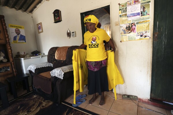 Elizabeth Mutandwa, 64, dresses up before going to attend an opposition rally in Zimbabwe's rural Domboshava area, Wednesday, Aug. 16 2023. People in Zimbabwe's rural areas claim they are facing intimidation and a biased state-run media which limits their ability to support opposition parties ahead of national elections next week. To combat that, one group of grandmothers is using the WhatsApp messaging app to spread information from the opposition party they support in an attempt to cut through the propaganda. (AP Photo/Tsvangirayi Mukwazhi)