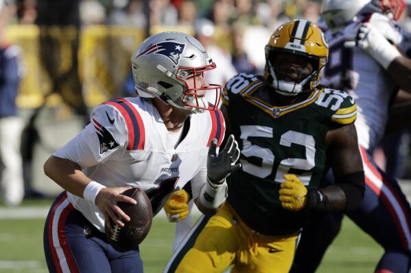 New England Patriots quarterback Bailey Zappe (4) runs from Green Bay Packers linebacker Rashan Gary (52) during the first half of an NFL football game, Sunday, Oct. 2, 2022, in Green Bay, Wis. (AP Photo/Mike Roemer)