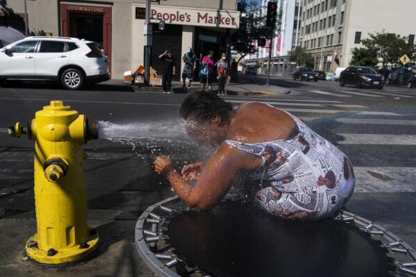 Stephanie Williams, 60, cools off with water from a hydrant in the Skid Row area of Los Angeles, Wednesday, Aug. 31, 2022. Excessive-heat warnings expanded to all of Southern California and northward into the Central Valley on Wednesday, and were predicted to spread into Northern California later in the week. (AP Photo/Jae C. Hong)