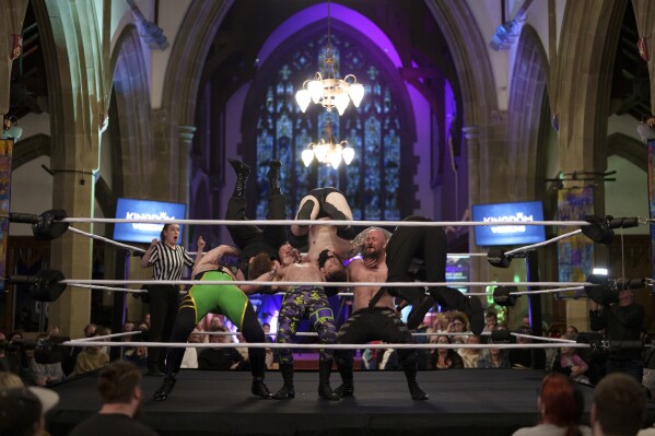 Una lucha de seis hombres se desarrolla en el ring durante un espectáculo de Kingdom Wrestling en la iglesia de San Pedro en Shipley, el sábado 29 de marzo de 2025. (Foto AP/Jon Super)