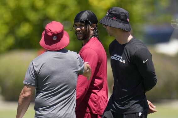 FILE - Arizona Cardinals quarterback Kyler Murray, center, talks with Cardinals offensive coordinator Drew Petzing, left, and head coach Jonathan Gannon during workouts at the NFL football team's training facility Monday, May 22, 2023, in Tempe, Ariz. Franchise quarterback Kyler Murray is still recovering from an ACL tear. (AP Photo/Ross D. Franklin, File)