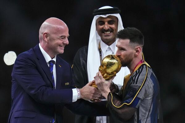 FILE - Argentina's Lionel Messi kisses the trophy presented by FIFA President Gianni Infantino, left, as The Emir of Qatar Sheikh Tamim bin Hamad Al Thani looks on, after the World Cup final soccer match between Argentina and France at the Lusail Stadium in Lusail, Qatar, Sunday, Dec. 18, 2022. The expanded World Cup in North America got even more supersized on Tuesday, March 14, 2023, The governing body of soccer increased the size of the 2026 tournament for the second time — six years after the first — by approving a bigger group stage for the inaugural 48-team event. (AP Photo/Manu Fernandez)