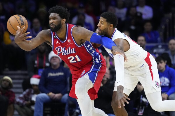 FILE - Philadelphia 76ers' Joel Embiid, left, tries to hang onto the ball against Los Angeles Clippers' Paul George during the first half of an NBA basketball game, Friday, Dec. 23, 2022, in Philadelphia. Paul George is going back to the Eastern Conference, and surely has made Joel Embiid very happy in the process. George will sign a four-year, $212 million contract with the Philadelphia 76ers, a person with knowledge of the move told The Associated Press early Monday, July 1, 2024. (AP Photo/Matt Slocum, File)