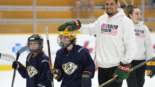 Minnesota Wild hockey player Ryan Reaves, right, of the NHL Player Inclusion Coalition pats Hayden Spalin on the head during a youth hockey clinic with NHL top draft prospects and members of the coalition, Tuesday, June 27, 2023, in Nashville, Tenn. (AP Photo/George Walker IV)