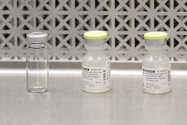 FILE - This March 16, 2020 file photo shows vials used by pharmacists to prepare syringes used on the first day of a first-stage safety study clinical trial of the potential vaccine for COVID-19, the disease caused by the new coronavirus, in Seattle. As the nation awaits a vaccine to end the pandemic, local health departments say they lack the staff, money and tools to distribute, administer and track millions of vaccines, most of which will require two doses. (AP Photo/Ted S. Warren, File)