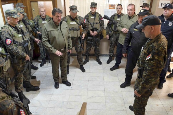 In this photo provided by the Serbian Interior Ministry, Serbian Interior Minister Bratislav Gasic speaks with police officers near the border between Serbia and Hungary, Serbia, Saturday, Oct. 28, 2023. Serbian police have arrested six people and seized automatic weapons after a shooting between migrants near the country's tense border with Hungary killed three people and injured one. (Serbian Ministry of Interior via AP)