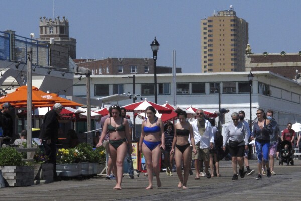 People walk on the boardwalk in Asbury Park, N.J. on May 21, 2021. On Feb. 23, 2024, New Jersey selected 18 Jersey Shore towns to split $100 million in funds to repair or rebuild their boardwalks. (AP Photo/Wayne Parry)