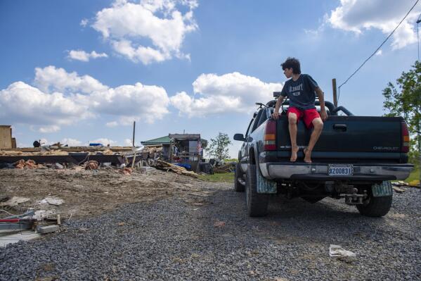 Jaylen Daigle, 16, looks back at what was once his grandparents home as he waits for them in the back of a truck near Pointe au Chien, La., Friday, Oct. 8, 2021. The family setup a portable shower and said for a while after the storm they were taking water from their pool to wash clothes. Louisiana residents grappling with severe home damage from Hurricane Ida and unable to shelter nearby may be eligible for a new program offering travel trailers and other temporary housing. (Chris Granger/The Times-Picayune/The New Orleans Advocate via AP)