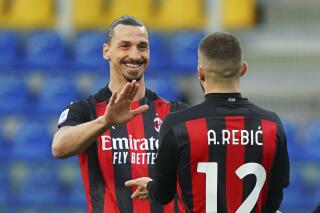Milan's Ante Rebic celebrates after scoring his side's first goal, with teammate Zlatan Ibrahimovic, who gave him the assist, during the Italian Serie A soccer match between Parma and Milan at the Ennio Tardini stadium in Parma, Italy, Saturday, April 10, 2021.  (Spada/LaPresse via AP)