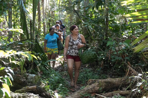 Juma Indigenous sisters Mandei Juma, right, and Borea Juma walk on a jungle path in their community, near Canutama, Amazonas state, Brazil, Sunday, July 9, 2023. Along with another sister, Mandei and Borea lead and manage the Indigenous territory after the death of their father in 2021. (AP Photo/Andre Penner)