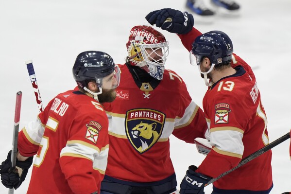 Florida Panthers center Sam Reinhart (13) celebrates with goaltender Sergei Bobrovsky, center, and defenseman Aaron Ekblad (5) after Reinhart scored during an overtime period of Game 4 during the Eastern Conference finals of the NHL hockey Stanley Cup playoffs to beat the New York Rangers, Tuesday, May 28, 2024, in Sunrise, Fla. (AP Photo/Wilfredo Lee)