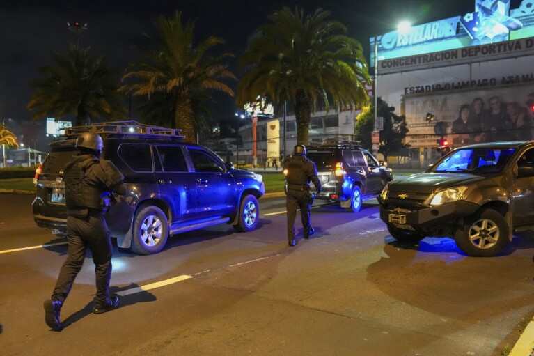 Policyjne pojazdy eskortujące szturmują ambasadę Meksyku w Quito w Ekwadorze, piątek, 5 kwietnia 2024 r. Ekwadorscy policjanci brutalnie wtargnęli do ambasady, w której ukrywał się były wiceprezydent Ekwadoru Jorge Glas, zaledwie kilka godzin po przekazaniu mu władzy politycznej przez rząd Meksyku.  szukać schronienia.  (AP Photo/Dolores Ochoa)