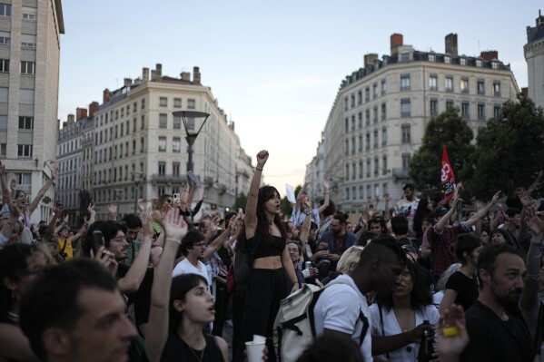 People stand in a square as they react to projected results after the second round of the legislative elections, in Lyon, central France, Sunday, July 7, 2024. Polls have closed in France, and polling projections say a coalition on the left that came together unexpectedly has won the most parliamentary seats in the pivotal runoff elections after a high turnout among voters. (ĢӰԺ Photo/Laurent Cipriani)