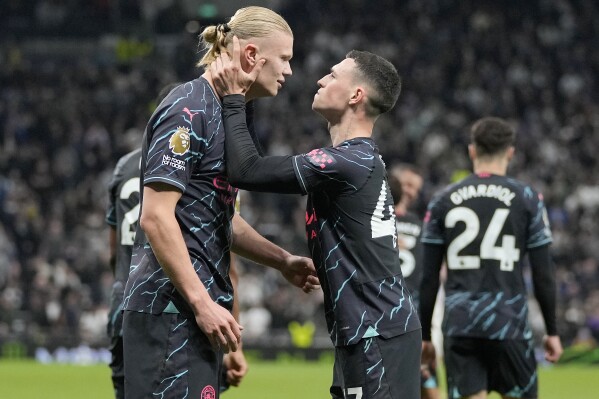 Manchester City's Erling Haaland and Manchester City's Phil Foden celebrate scoring their side's second goal during the English Premier League soccer match between Tottenham Hotspur and Manchester City at Tottenham Hotspur Stadium in London, Tuesday, May 14, 2024.(AP Photo/Kin Cheung)