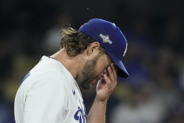 Los Angeles Dodgers starting pitcher Clayton Kershaw rubs his face after Arizona Diamondbacks' Alek Thomas scored off an RBI double by Evan Longoria during the first inning in Game 1 of a baseball NL Division Series Saturday, Oct. 7, 2023, in Los Angeles. (AP Photo/Mark J. Terrill)