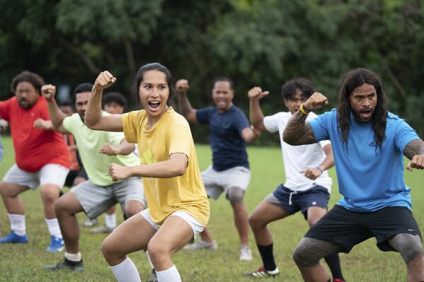 This image released by Searchlight Pictures shows Kaimana, foreground left, and Hilo Pelesasa, right, in a scene from "Next Goal Wins." (Hilary Bronwyn Gayle/Searchlight Pictures via AP)