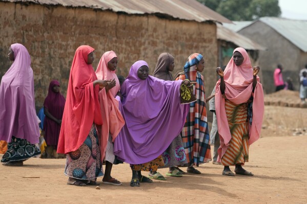 Parents wait for news about the kidnapped LEA Primary and Secondary School Kuriga students in Kuriga, Kaduna, Nigeria, Saturday, March 9, 2024. Security forces swept through large forests in Nigeria's northwest region on Friday in search of nearly 300 children who were abducted from their school a day earlier in the West African nation's latest mass kidnap which analysts and activists blamed on the failure of intelligence and slow security response. (AP Photo/Sunday Alamba)