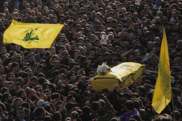 Mourners carry the coffin of senior Hezbollah commander Wissam Tawil during his funeral procession in the village of Khirbet Selm, south Lebanon, Tuesday, Jan. 9, 2024. The elite Hezbollah commander who was killed in an Israeli airstrike Monday in southern Lebanon fought for the group for decades and took part in some of its biggest battles. (AP Photo/Hussein Malla)
