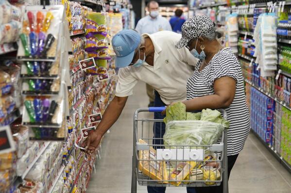 FILE - Ray Carter, left, and Bobbie Carter right, shop at the new Homeland grocery store, Wednesday, Sept. 1, 2021, in Oklahoma City.  Consumers facing higher prices for products made with corn and wheat could be in for more pain as global supplies tighten because of Russia’s invasion of Ukraine. Wheat and corn prices have each jumped more than 20% so far this year, surpassing their gains for all of 2021.  (AP Photo/Sue Ogrocki, File)