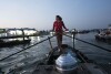 2024 年 1 月 17 日星期三，在越南芹苴，阮氏翠 (Nguyen Thi Thuy) 是一名在水上市场卖馒头的小贩，她划着小船。天气好的时候，她的收入约为 4 美元，几乎不足以维持餐桌上的食物。  （美联社照片/Jae C. Hong）