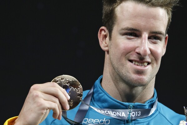 Australia's James Magnussen smiles as he hold the gold medal he won in the Men's 100m freestyle final at the FINA Swimming World Championships in Barcelona, Spain, on Aug. 1, 2013. (AP Photo/Michael Sohn, File)