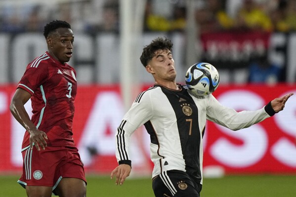 Germany's Kai Havertz, right, controls the ball as he is challenged by Colombia's Jhon Lucumi during an international friendly soccer match between Germany and Colombia at Veltins-Arena, in Gelsenkirchen, Germany, Tuesday, June 20, 2023. (AP Photo/Martin Meissner)