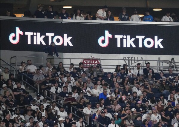 FILE - Fans sit under a TikTok ad at a baseball game at Yankee Stadium, April 14, 2023, in New York. A bill that could lead to the popular video-sharing app TikTok being unavailable in the United States is quickly gaining traction in the House. Lawmakers advanced legislation against TikTok Thursday as they voiced concerns about the potential for the platform to surveil and manipulate Americans. (AP Photo/Frank Franklin II, File)