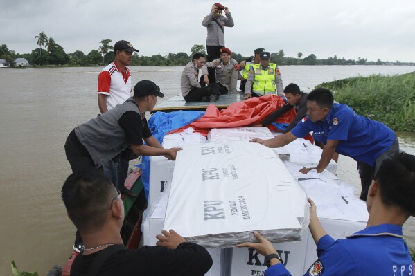 Electoral workers arrange ballot boxes in a boat during the distribution of election paraphernalia to remote villages, in Pemulutan, South Sumatra, Indonesia, Tuesday, Feb. 13, 2024. Indonesia, the world's third-largest democracy, will open its polls on Wednesday, Feb. 14, to nearly 205 million eligible voters in presidential and legislative elections, the fifth since Southeast Asia's largest economy began democratic reforms in 1998. (AP Photo/Muhammad Hatta)