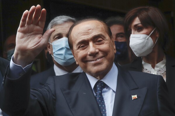 FILE - Former Italian Premier Silvio Berlusconi waves to reporters as he arrives at the Chamber of Deputies to meet Mario Draghi, in Rome, Feb. 9, 2021. Berlusconi, the boastful billionaire media mogul who was Italy's longest-serving premier despite scandals over his sex-fueled parties and allegations of corruption, died, according to Italian media. He was 86. (AP Photo/Alessandra Tarantino, File)