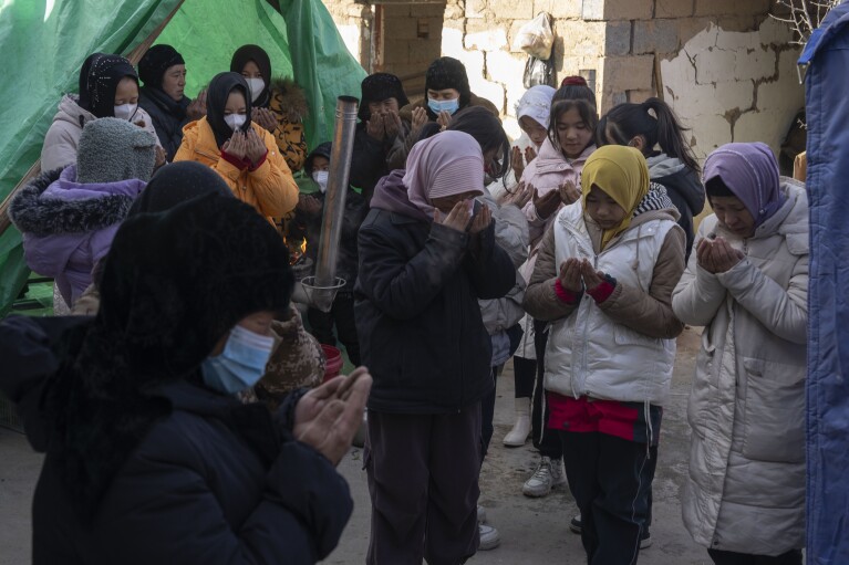 Female relatives pray during rituals for Han Suofeiya who was killed in an earthquake in Yangwa village near Dahejia town in northwestern China's Gansu province, Wednesday, Dec. 20, 2023. (AP Photo/Ng Han Guan)