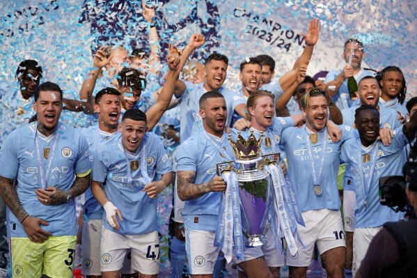 Manchester City's Kyle Walker celebrates with the Premier League trophy after the English Premier League soccer match between Manchester City and West Ham United at the Etihad Stadium in Manchester, England, Sunday, May 19, 2024. Manchester City clinched the English Premier League on Sunday after beating West Ham in their last match of the season. (AP Photo/Dave Thompson)