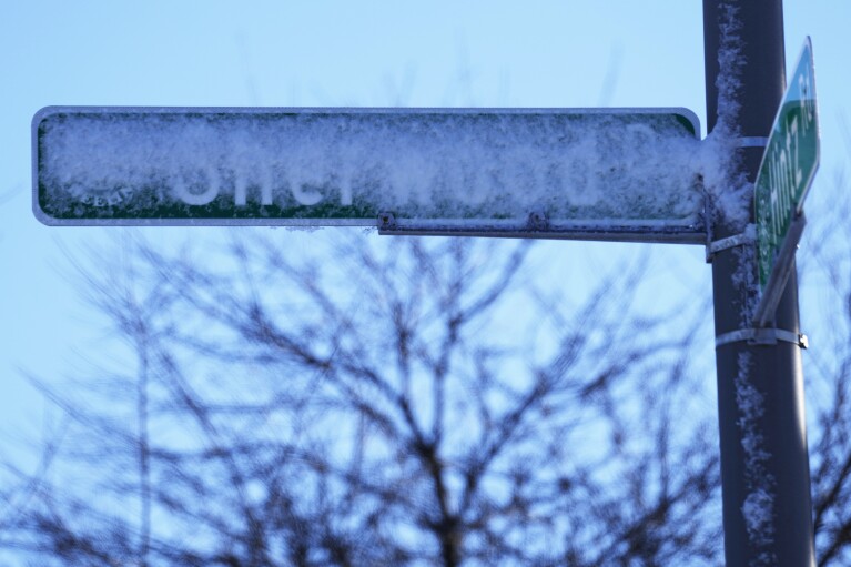 Road signs are covered with snow in Prospect Heights, Illinois on Sunday, January 14, 2024.  A wind chill warning is in effect as dangerously cold conditions continue in the Chicago area.  (AP Photo/Nam Y. Huh)