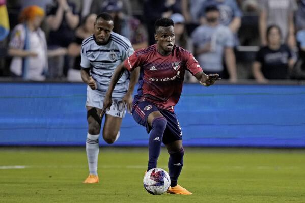 FC Dallas forward Jáder Obrian is chased by Sporting Kansas City midfielder Gadi Kinda (10) during the first half of an MLS soccer match Wednesday, May 31, 2023, in Kansas City, Kan. (AP Photo/Charlie Riedel)